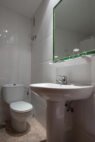 ein Badezimmer mit Waschbecken, Toilette und Spiegel in der Unterkunft Hotel Riviera in Córdoba