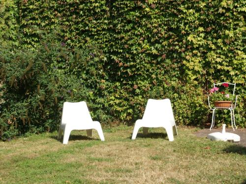two white chairs sitting in the grass with a table at Holiday home in Vic sur Seille near the forest in Vic-sur-Seille