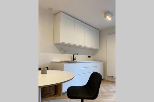 萊茵巴赫的住宿－Design-Ferienwohnung an der Madbachtalsperre，一个带桌子和黑椅子的小厨房