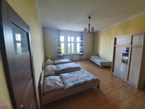 duas camas num quarto com duas janelas em Pokoje Gościnne NAP em Katowice