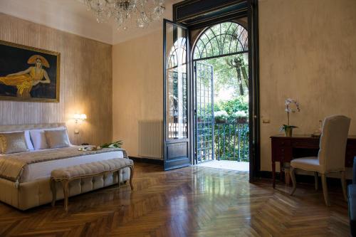 a bedroom with a bed and a table and a window at Contessa Arrivabene Antica Dimora in Rome