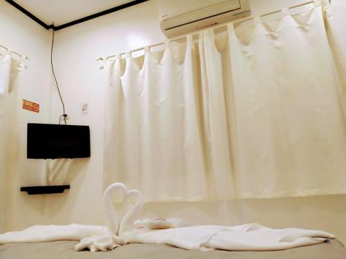 a room with a bed with a white curtain at Monallan Boracay Hotel in Boracay