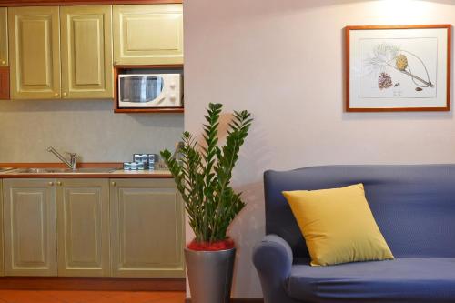 a blue couch in a kitchen with a potted plant at Residence Del Messaggero in Rovereto