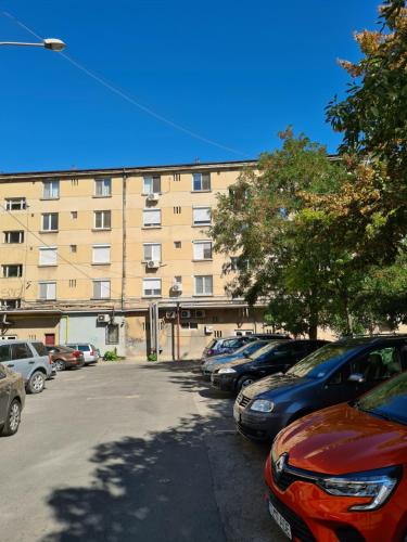 a parking lot with cars parked in front of a building at Mia Apartament in Tulcea