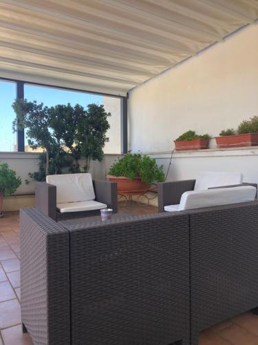 an outdoor patio with wicker chairs and a table at Visa Residence in Bari