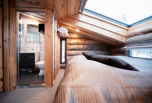 een slaapkamer met een bed en een badkamer met een raam bij Veskaranta Sky View Villas in Ruka