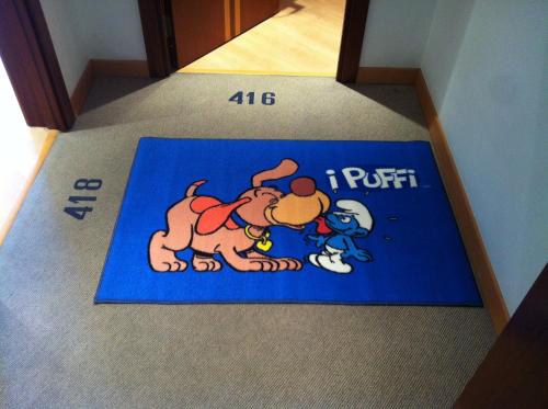 a blue rug with a picture of a dog and a cartoon at Hotel Europa Beach Village in Giulianova