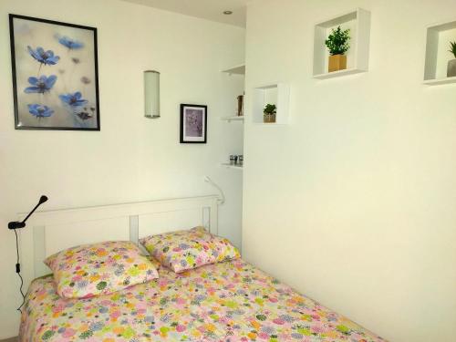 - une chambre avec un lit fleuri dans l'établissement 2 pièces- rue piétonne Trouville -Le petit juliana, à Trouville-sur-Mer