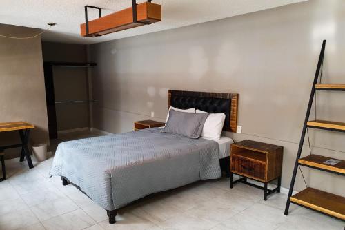 1 dormitorio con 1 cama y 2 mesitas de noche en Hotel Diez, en Celaya