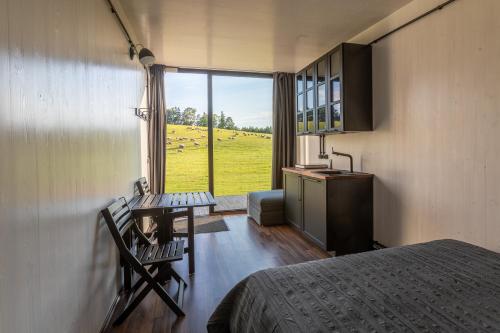 una camera con letto e una cucina con finestra di Unique Tiny House getaway in the nature - Kenshó a Puugi