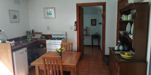 a kitchen with a table and a stove top oven at The Innlet, Country Apartments and Cottages in Collingwood