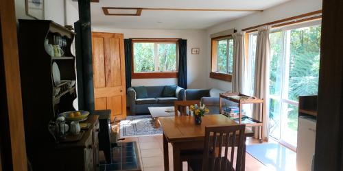 uma sala de estar com uma mesa e um sofá em The Innlet, Country Apartments and Cottages em Collingwood