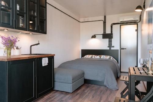 a small bedroom with a bed and a kitchen at Unique Tiny House getaway in the nature - Kenshó in Puugi