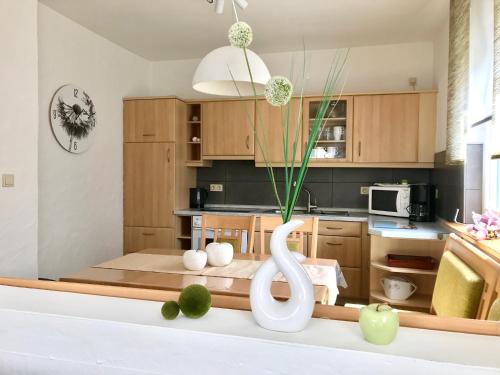 Una cocina con un jarrón blanco sobre una mesa. en Ferienhaus 2 An der Rodach, en Steinwiesen