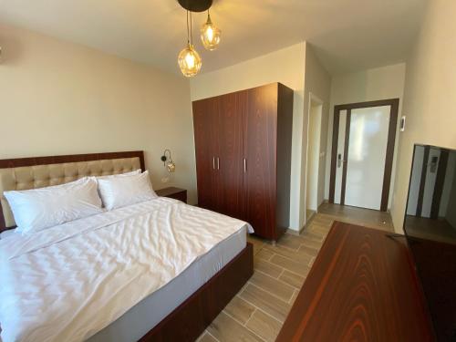 a bedroom with a large white bed and a television at Hotel Kolonja's in Debar
