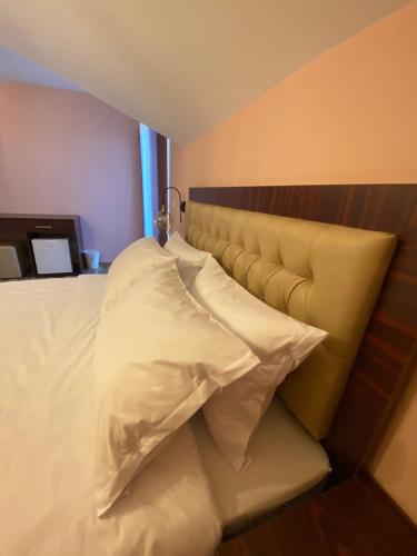 a bed with two pillows on it in a room at Hotel Kolonja's in Debar
