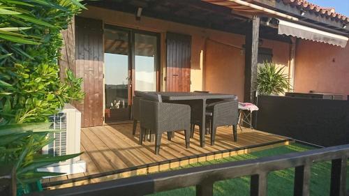 une terrasse en bois avec une table et des chaises sur une maison dans l'établissement Vue panoramique exceptionnelle, au Lavandou