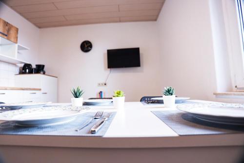 a dining room with plates and utensils on a table at cosy apartment in Neupetershain with Wifi in Neupetershain