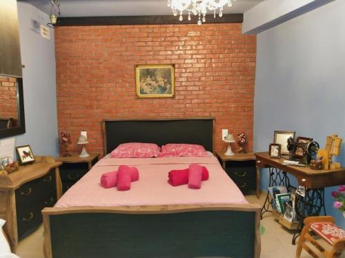 una camera da letto con un letto con guanti rosa sopra di Mama's Cozy Room 1 a Kalabaka