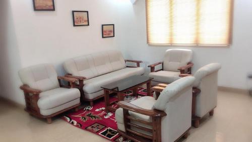 a living room with two chairs and a table at Swarna Sudarshan Service Apartment @ Adyar chennai in Chennai