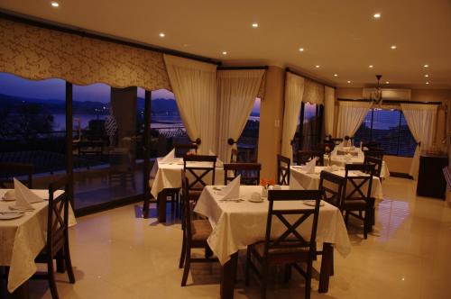 a restaurant with tables and chairs with a view at Château La Mer Exclusive Guesthouse & Spa in Hartbeespoort