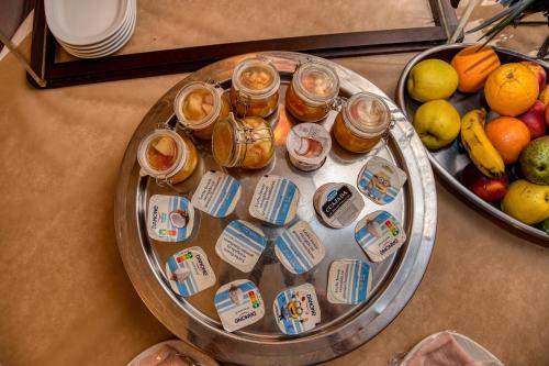 a table with jars of honey and a tray of fruit at Hotel Castilla Vieja in Palencia