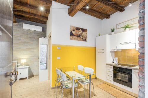 a kitchen with a table and chairs and a yellow wall at Nel cuore di Ferrara in Ferrara