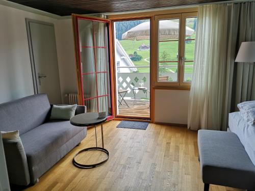 a living room with a couch and a table at Gasthaus Friedegg in Wildhaus