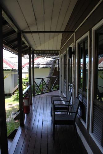a porch of a house with two chairs on it at 1511 Coconut Grove in Tioman Island