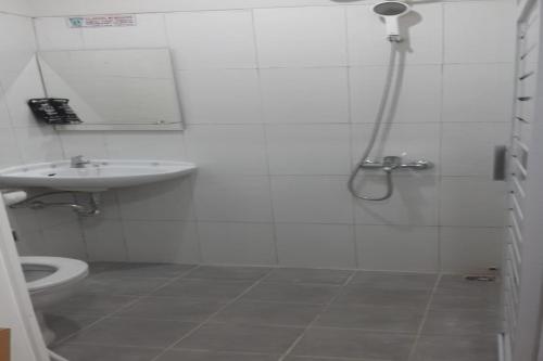 a bathroom with a shower and a toilet and a sink at RedDoorz Syariah near UNSOED in Purwokerto