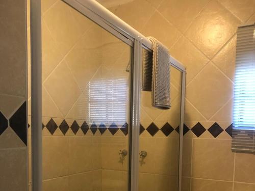 a shower with a glass door in a bathroom at African Dreamz Guest House in St Lucia