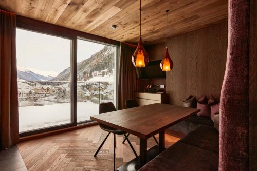 a room with a table, chairs and a window at Hotel Alpina in Ischgl