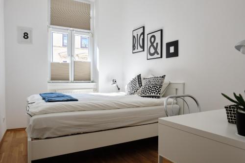 een bed in een witte kamer met een raam bij Vienna Experience in Wenen