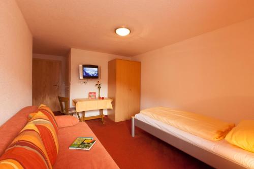 a room with a bed and a table with a television at Holzgauerhof in Holzgau
