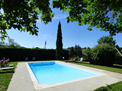 - une piscine dans une cour avec des chaises dans l'établissement inspiration by balladins Villefranche-de-Rouergue, à Villefranche-de-Rouergue