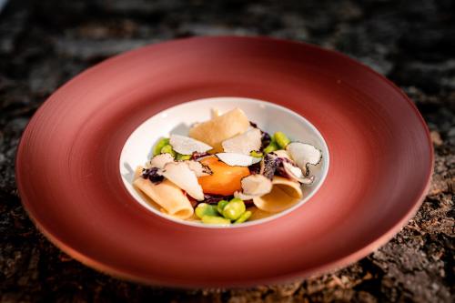 a red bowl of food on a red plate at Parkhotel Herne in Herne