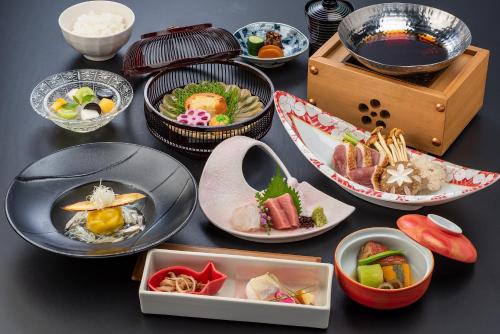 a table topped with plates and bowls of food at Ishinoya Izunagaoka - TKP Hotels & Resorts in Izunokuni