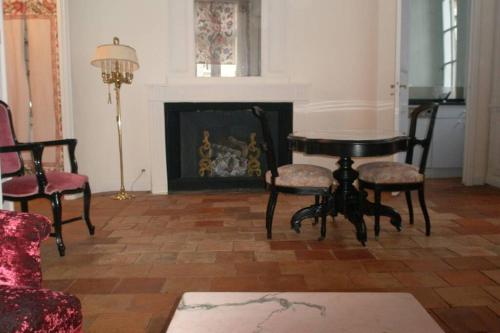 a living room with a table and chairs and a fireplace at Logis de Sainte-Scarbes in Toulouse