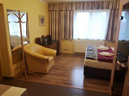 Cette chambre comprend un lit, une chaise et une fenêtre. dans l'établissement Apartment Hanspaulka Garden, à Prague