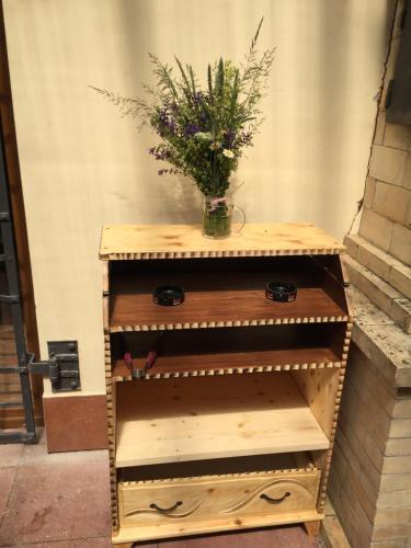 a wooden dresser with a vase of flowers on it at Chalupa - Sklep Starovice in Starovice