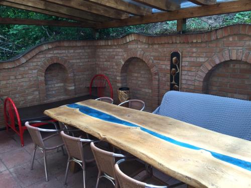 a wooden table with chairs and a brick wall at Chalupa - Sklep Starovice in Starovice