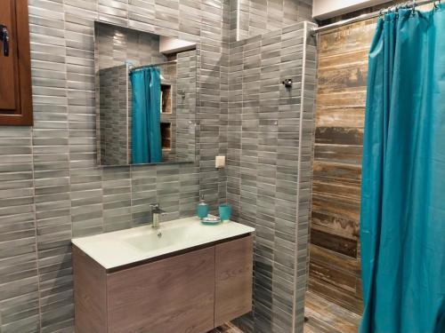 a bathroom with a sink and a mirror and a shower at Mama's Cozy Room 2 in Kalabaka