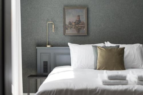 Un dormitorio con una cama blanca con una foto en la pared en Ysbrantsz Boutique Hotel en Hoorn