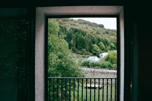 a door to a balcony with a view of a mountain at hostal iratibizkar in Ochagavía