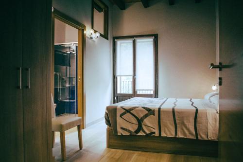 a bedroom with a bed and a window and a chair at hostal iratibizkar in Ochagavía