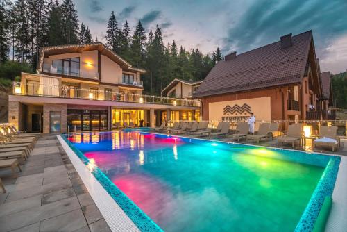 a house with a swimming pool in front of a house at Karpatski Hotel & Spa in Bukovel