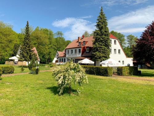 a large white house with a red roof at Landhotel Cafe Prälank in Neustrelitz