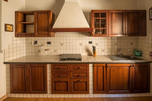 cocina con armarios de madera y encimera en caratteristico appartamento Grazia centro storico, en San Gimignano
