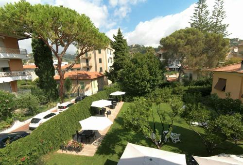 een uitzicht over de tuin met bomen en gebouwen bij Gold Hotel in Bordighera