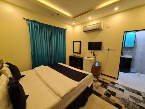 a bedroom with a large bed and a television at Rekaz Aparthotel in Mecca